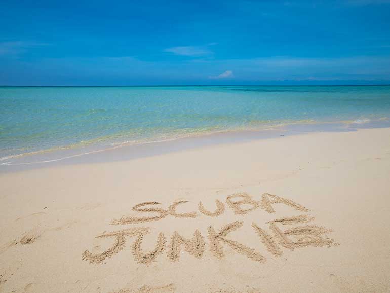 scuba junkie written on the beach